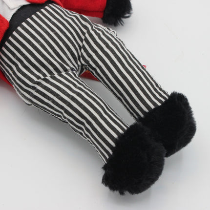 A close-up of a Golly doll's legs wearing black and white vertically striped pants with fluffy black boot covers, set against a plain white background.