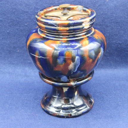 Decorative ceramic tobacco jar with multicolored design on a blue background