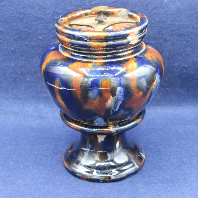 Decorative ceramic tobacco jar with multicolored design on a blue background