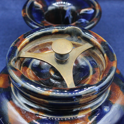 Close-up of a ceramic grinder with a gold center on a blue background