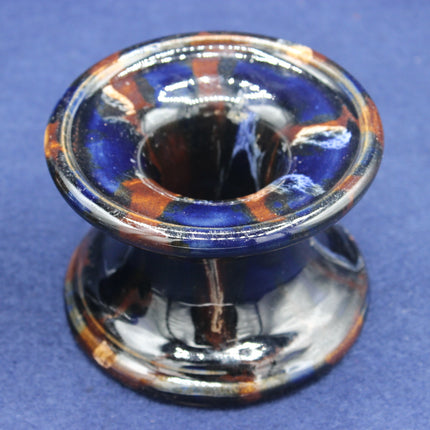 Ceramic vase with blue and orange glaze on a blue background