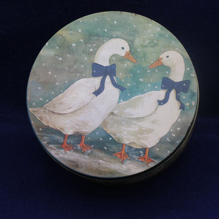 Decorative plate with two ducks wearing blue bows on a snowy background