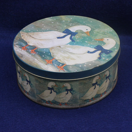 Round tin box with duck design on a blue background