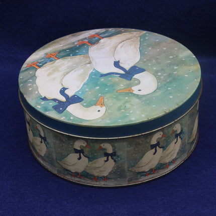 Round tin box with goose design on a blue background