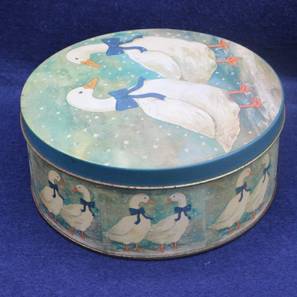 Round tin box with goose design on a blue background