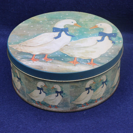 Round tin box with duck design on a blue background