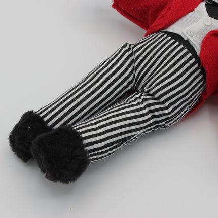 A close-up of a Golly doll's legs wearing black and white striped trousers with fluffy black boot cuffs, a white shirt, and a red jacket, on a plain white background.