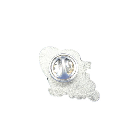 A silver metal lapel pin shown from the back, featuring a textured outline of a cartoon character and a circular pin clasp, placed on a textured blue background.