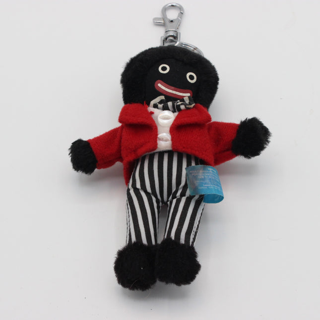 A plush  Golly character keychain featuring a black fuzzy head and hands, a bright red jacket, black-and-white vertically striped pants, and a silver metal key ring at the top, photographed on a plain white background.