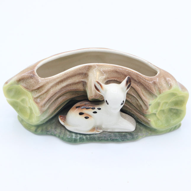 A ceramic woodland-themed planter shaped like a hollow log with a small white deer figurine nestled underneath, set against a plain white background.