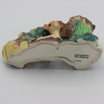 Vintage ceramic figurine of a deer nestled among green foliage and brown branches, displayed on its cream-colored base with a visible Horngsea Marlowe 'Fauna' brand mark.