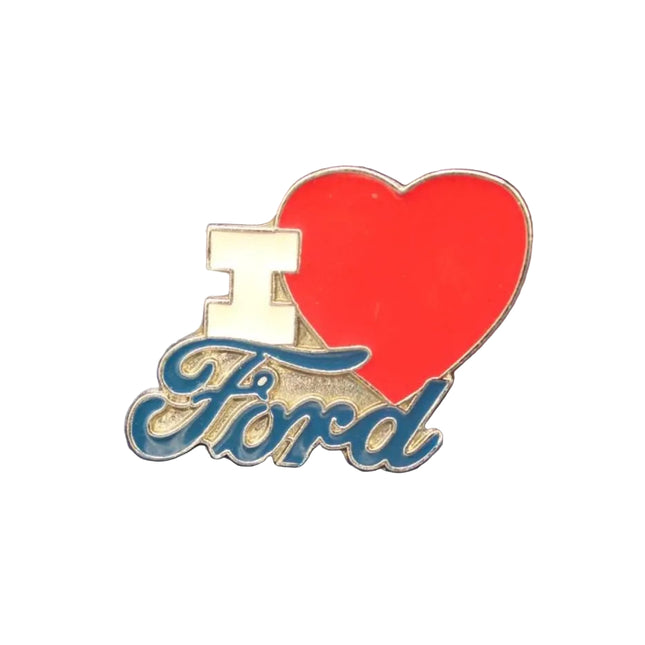 An enamel lapel pin featuring a red heart, a gold block 'I', and the word 'Ford' in blue cursive script, displayed on a textured dark blue background.