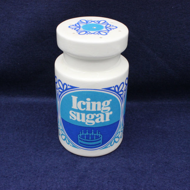 Icing sugar shaker with blue label on a dark blue background