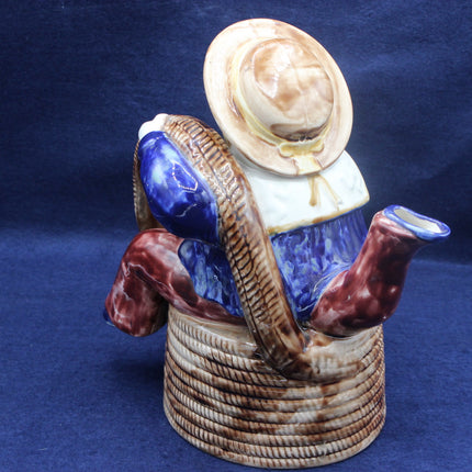 Ceramic figure of a sailor with a hat and fishing rod on a blue background