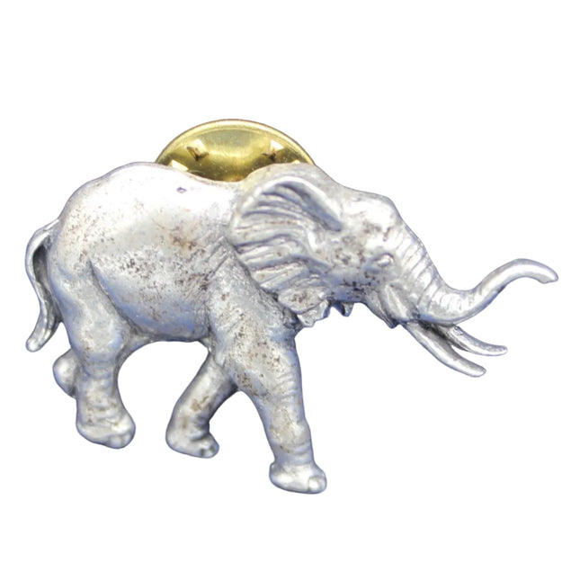 Silver elephant figurine with a gold coin on its back against a blue background