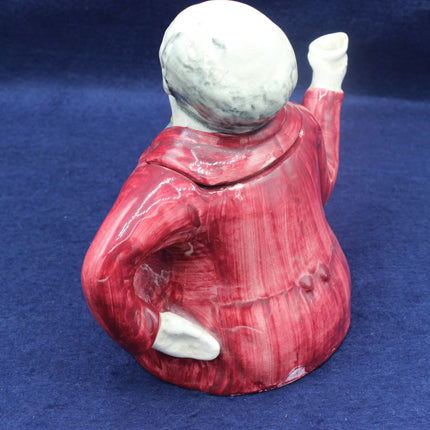 Ceramic teapot with a face on a blue background