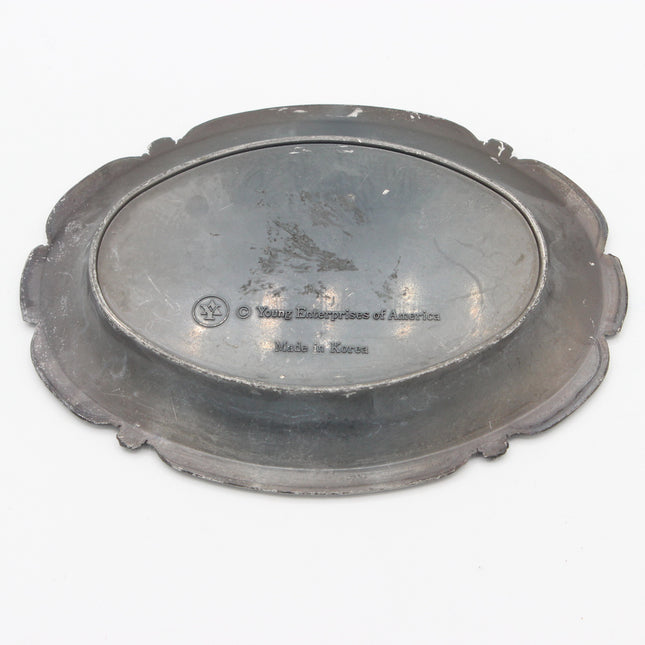 An antique oval metal serving platter with a scalloped rim, shown from a top-down perspective on a white background. The center features engraved text reading 'Young Enterprise of America' and 'Made in Korea'.