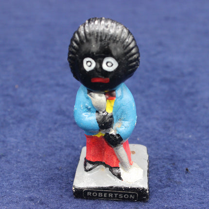 Figurine of a character with a black topknot, blue jacket, and red pants on a blue background.