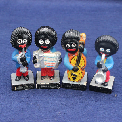 Four golliwog figurines playing musical instruments on a blue background