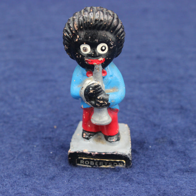 Vintage figurine of a black figure in a blue coat with a red scarf, holding a megaphone on a blue background.