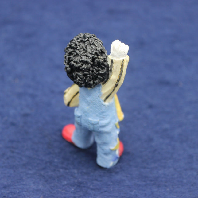 Small Golly figurine of a person with a backpack on a blue background