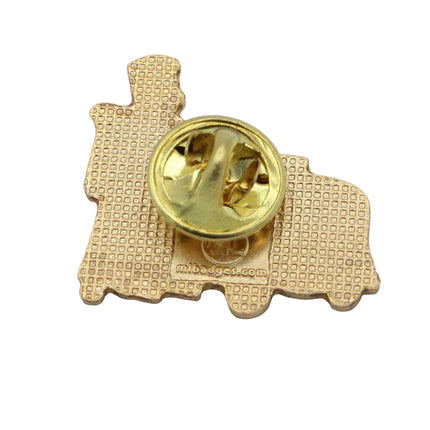 A small gold-toned train-shaped pin or badge with a textured patterned face and a shiny circular clasp, photographed on a plain light gray background.