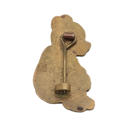 A small vintage-style metal pin or charm shaped like a rabbit silhouette, shown from the back on a plain white background. The item appears aged with a warm metallic finish and a pin clasp attached at the top.