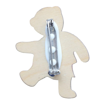 Wooden teddy bear-shaped object with a silver cylindrical component on a blue background