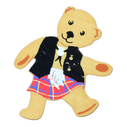 Teddy bear in a kilt on a blue fabric background