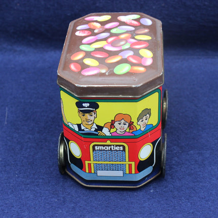 Colorful tin toy truck with a transparent top showing candy on a blue background