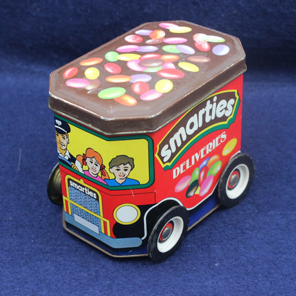 Toy truck-shaped container of Smarties on a blue background