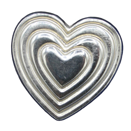 Silver heart-shaped object on a blue fabric background