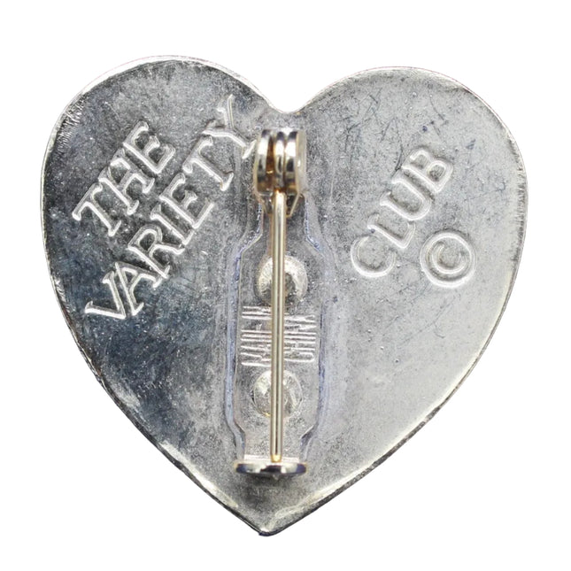 Heart-shaped metal badge with 'The Variety Club' text on a white background