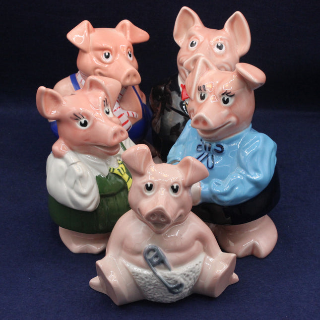 Four ceramic pig figurines wearing colorful shirts on a dark background