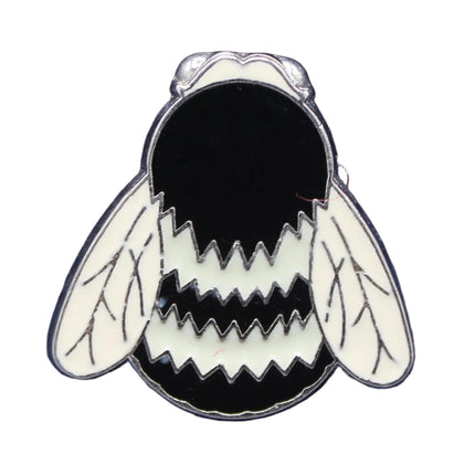 Bee-shaped pin on a blue fabric background