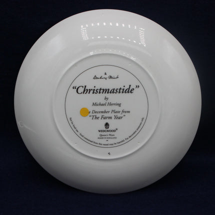 White Wedgwood plate with 'Christmastide' inscription on a black background
