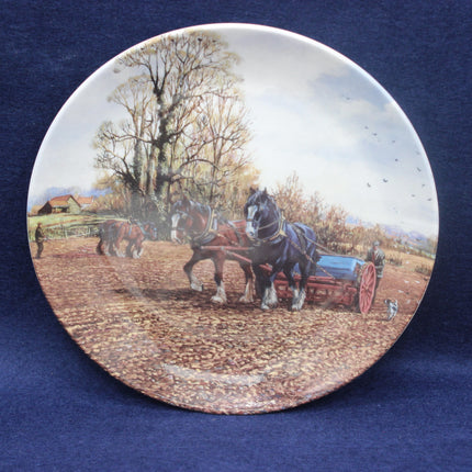 Ceramic plate with a rural scene of horses pulling a cart on a blue background