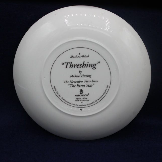 White Wedgwood plate with 'Threshing' inscription on a black background