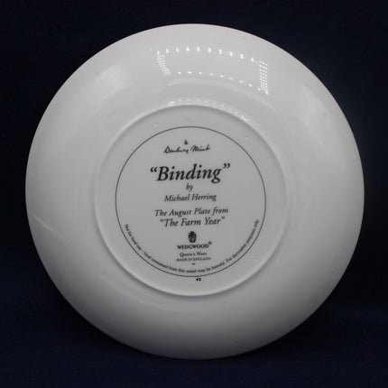 White ceramic plate with 'Binding' by Michael Herring on a black background
