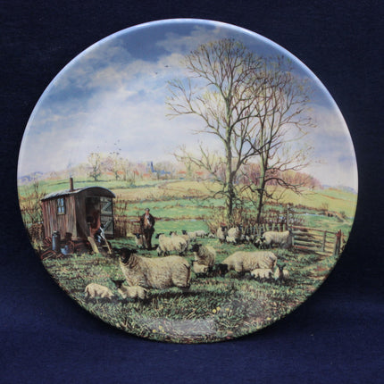 Decorative plate with a pastoral scene of sheep and shepherds in a field.