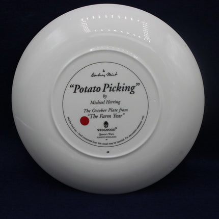 White Wedgwood plate with 'Potato Picking' design on a black background