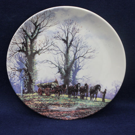 Decorative plate with a pastoral scene of horses and a cart under trees.