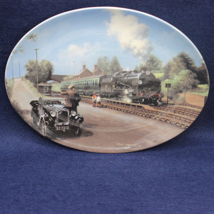 Decorative plate with a steam train and vintage car on a scenic railway track.