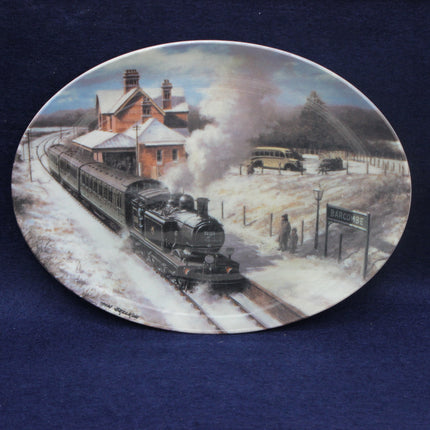 Decorative plate with a steam train scene at a station on a blue background