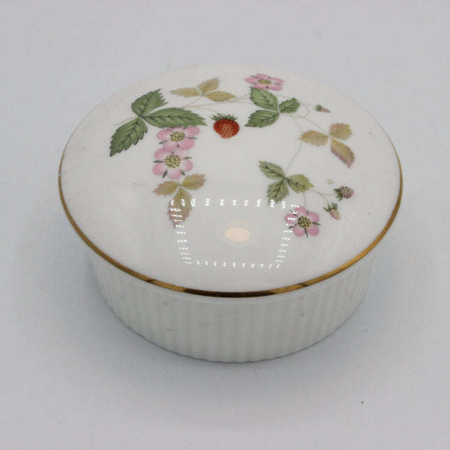 A round white porcelain keepsake box with a lid decorated with a delicate pink strawberry floral pattern and a thin gold trim, set against a plain light gray background.