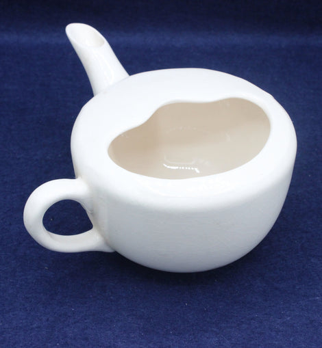 White ceramic jug with a spout on a blue background