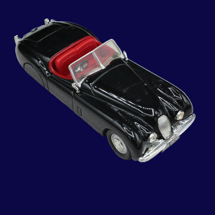 Model car with a black body and red interior on a gray background