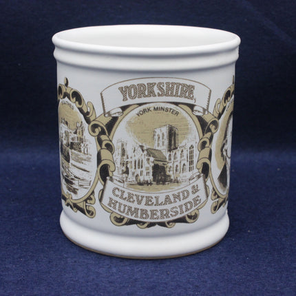 White mug with black and gold Yorkshire-themed design on a blue background