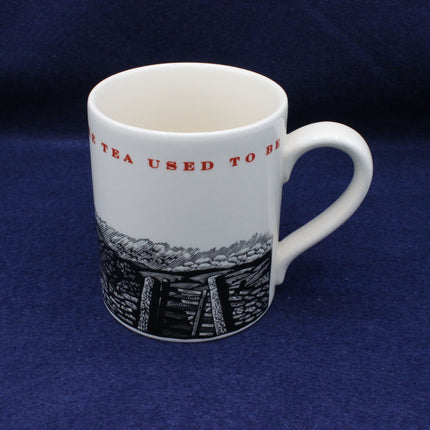 White mug with black and red design on a blue background