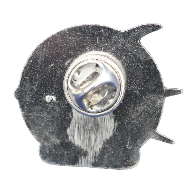 Metallic pin with a fish-shaped back on a blue textured background